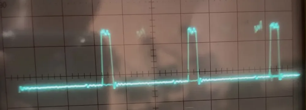 Analog oscilloscope screen showing a train of short, regularly spaced pulses on the ALE pin
