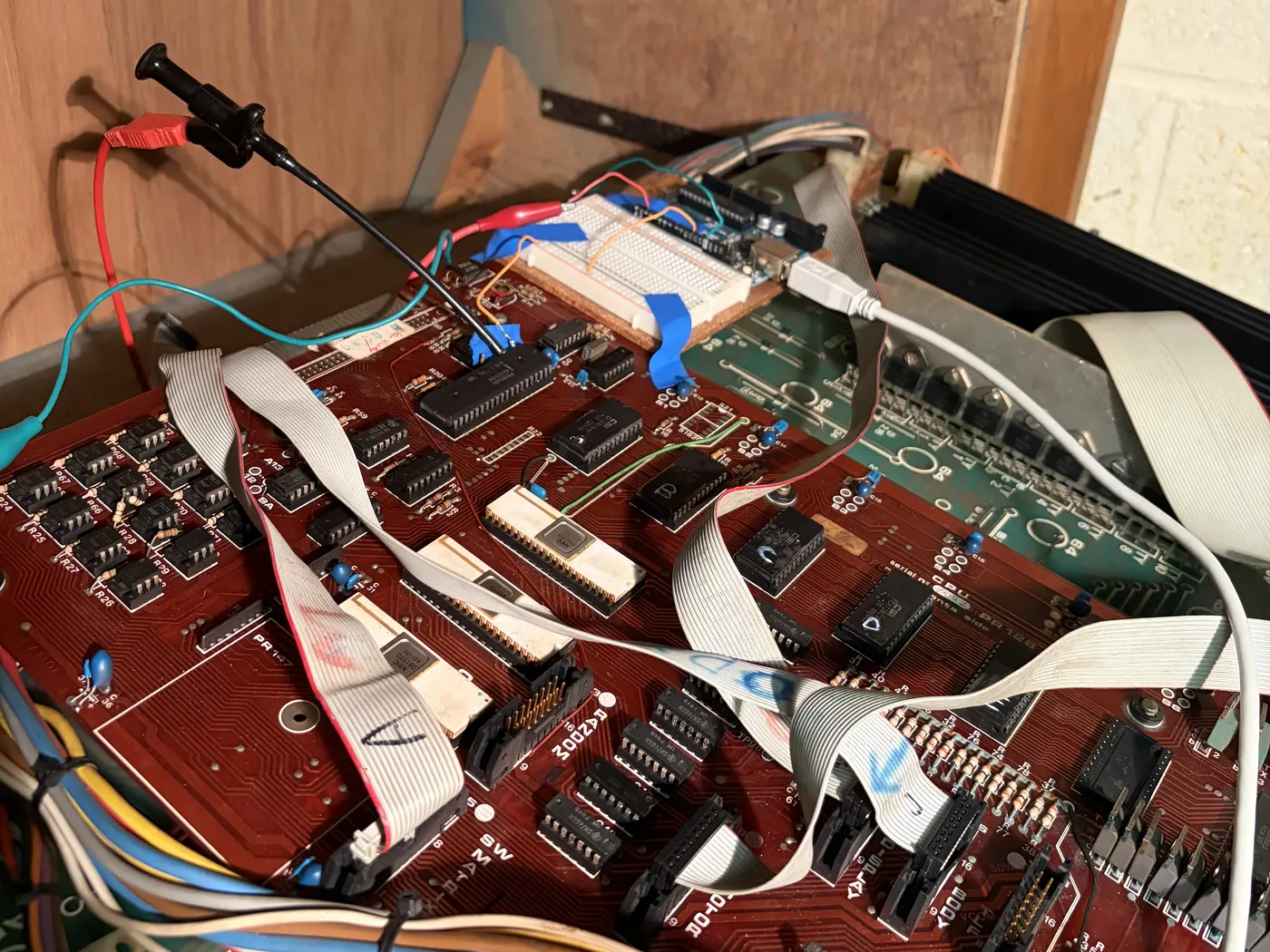 The CPU board in the machine, with a breadboard and Arduino sitting on top of it, wired to the 8085's clock pins