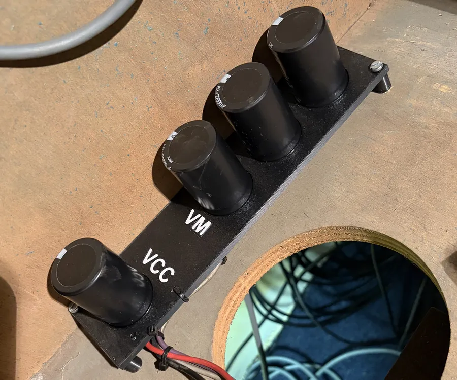 Four new black capacitors in a 3D printed mount in the bottom of the cabinet, labelled VCC and VM